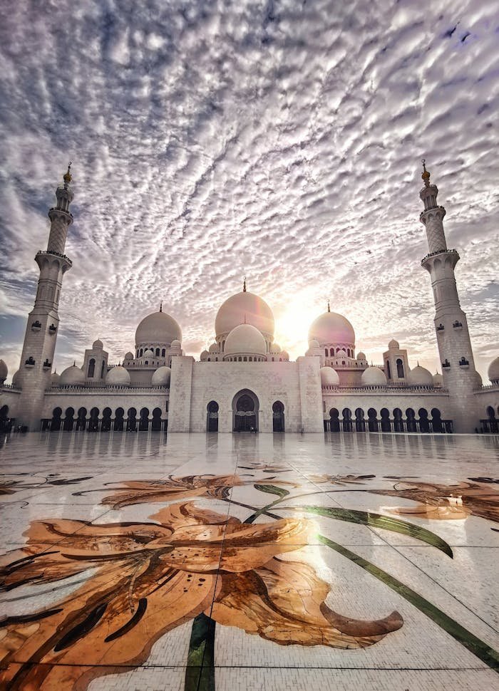 Home Sunset at the Sheikh Zayed Mosque showcasing stunning architectural beauty and cloud formations.